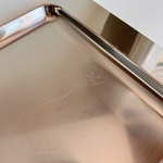 Alessi metal tray reflecting light, minimalist setting