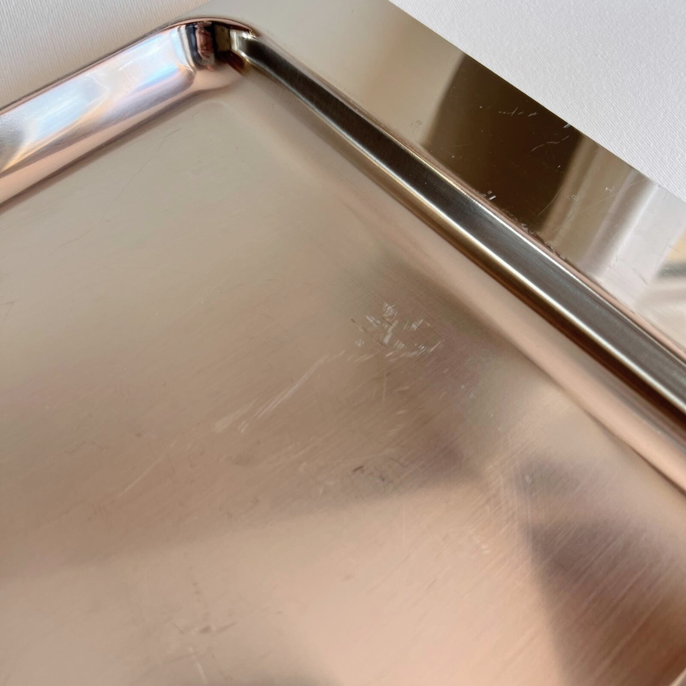 Alessi metal tray reflecting light, minimalist setting