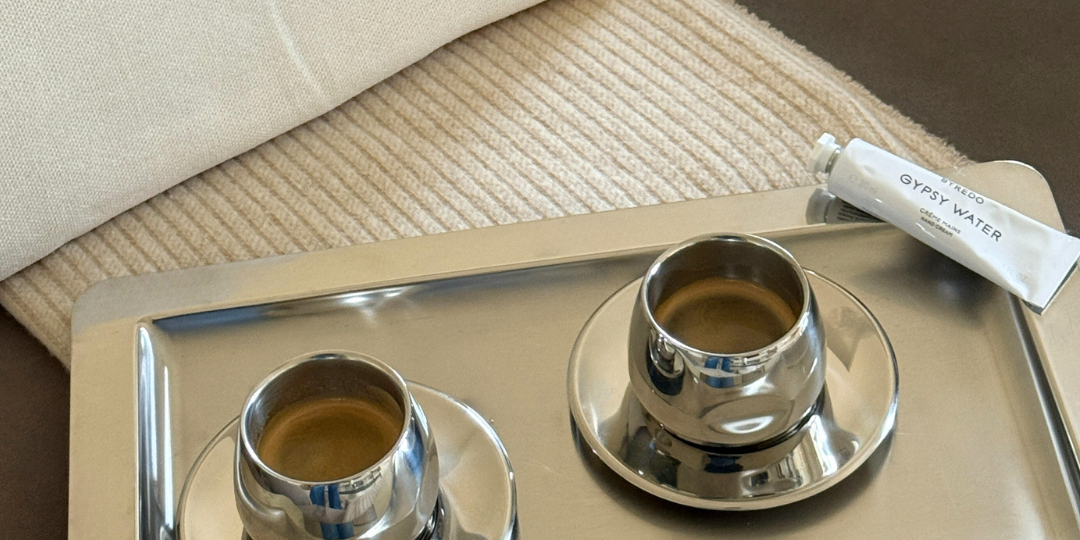 2 amc art design coffee cups on a tray on a blanket