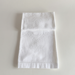 White embroidered cotton hand towel laid flat