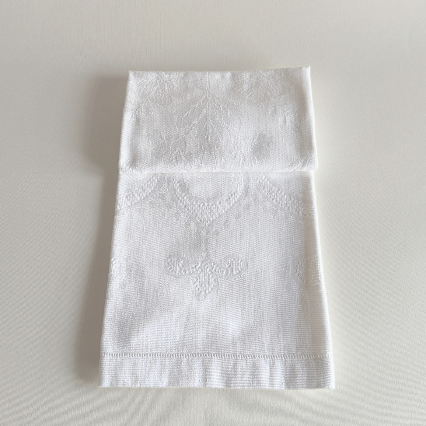 White embroidered cotton hand towel laid flat