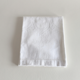 Close view of the hand-stitched embroidered motif on the cotton towel