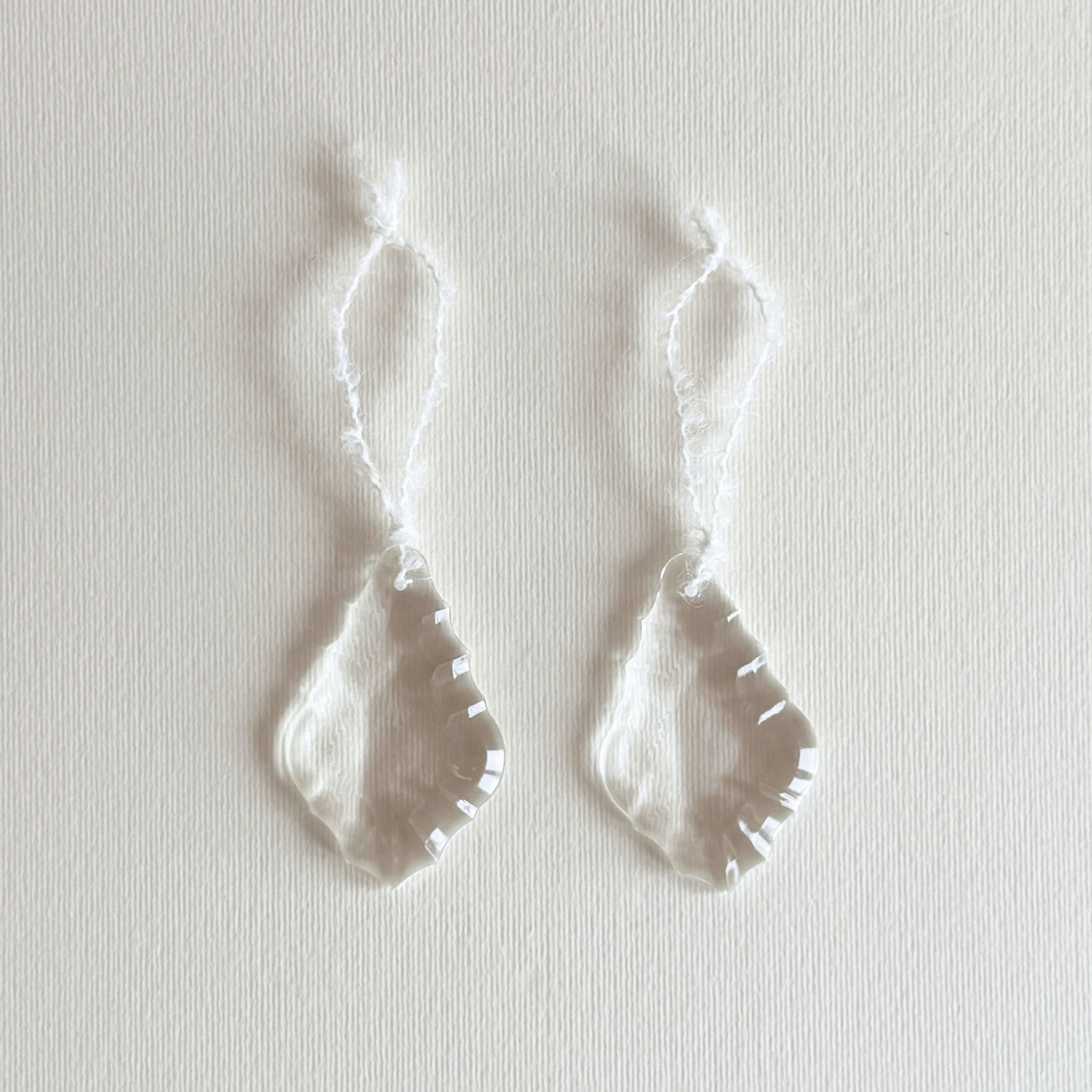 Glass Leaf Prism Christmas Ornament set of two, clear faceted glass almond-leaf drops with white wool hanging loops.