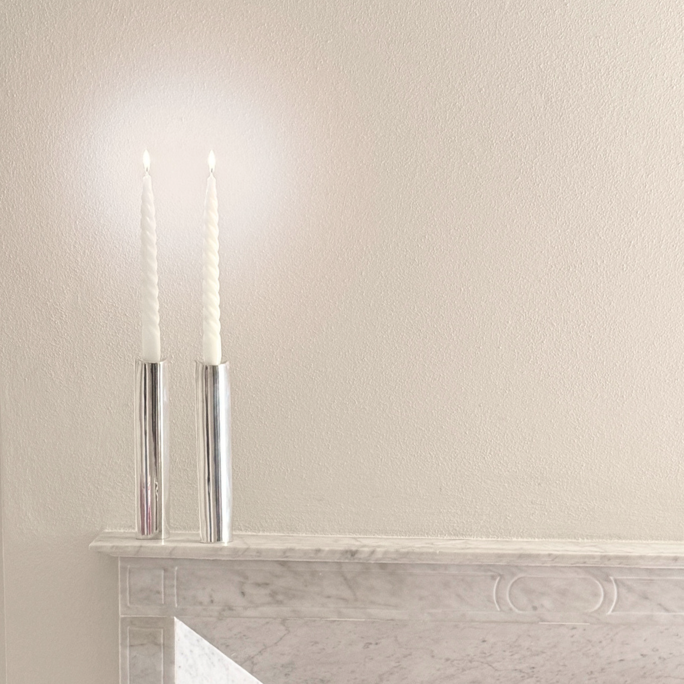 Silver Plated Candle Holders, a matching pair of polished cylindrical silver-tone holders with tall white candles.