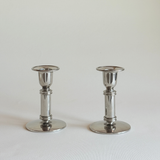 Polished stainless steel candle holder detail, steel column and flat round base, L'Officina General Store