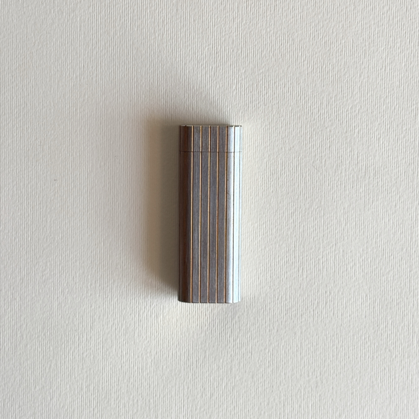 Vintage Cartier table lighter in stainless steel with gold-plated ribbed detail, front view