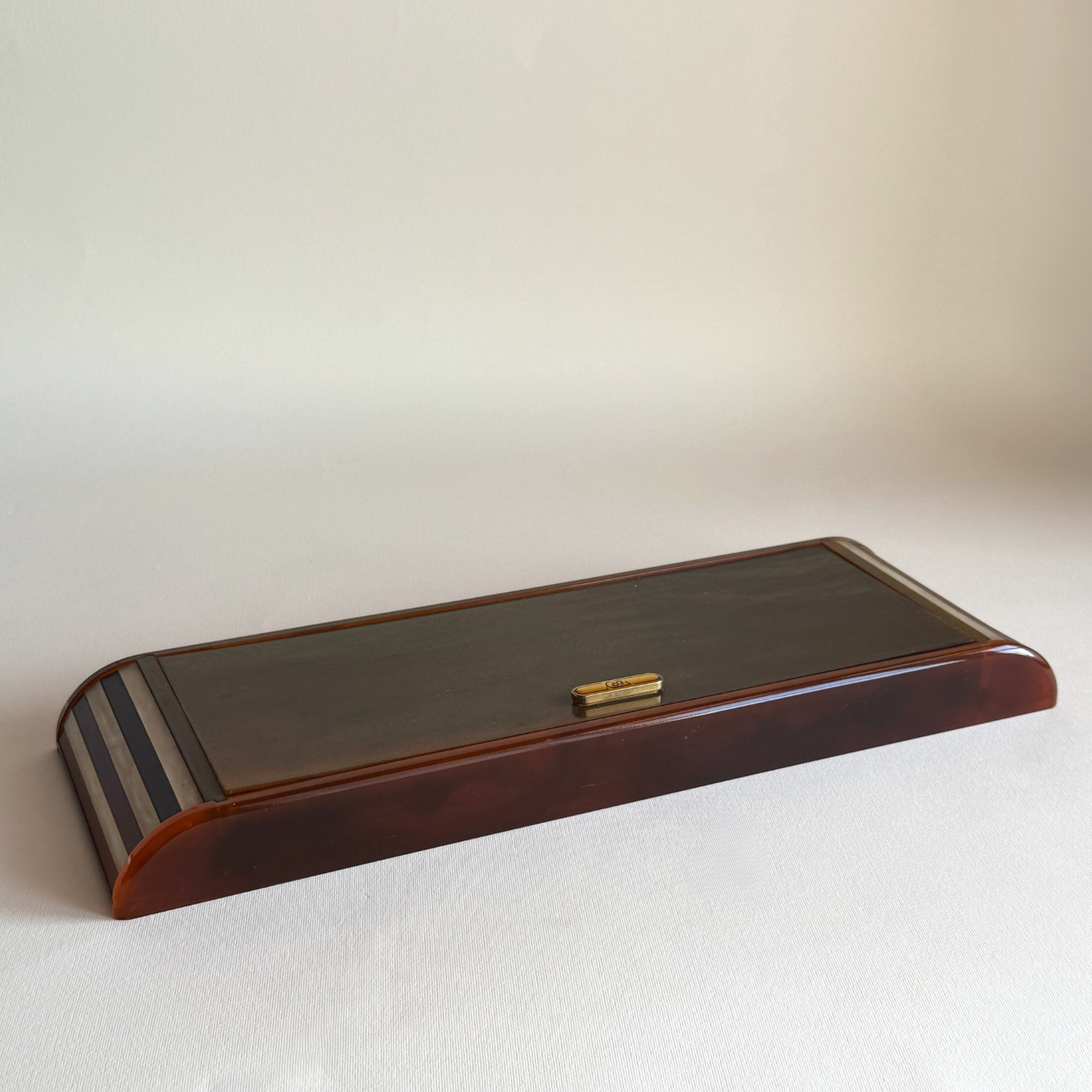 Tortoiseshell Lucite games set open, showing two card decks, poker dice and ivory and brown chips