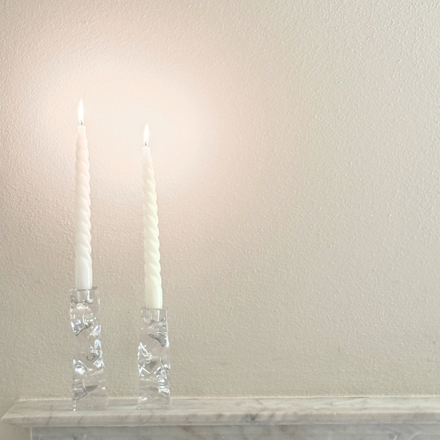 Crystal Candle Holders, a pair of clear faceted glass candle holders with tapered columns and polished rims, holding white spiral tapers.