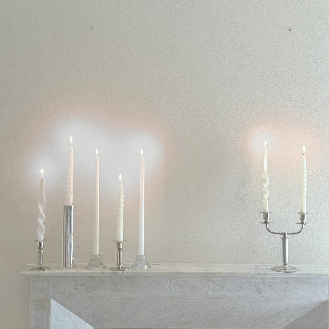 Letang Remy two-arm candle holder in polished stainless steel, with a slender central stem and curved arms holding candles.