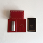 Cartier Les Must table lighter in silver steel with gold trim, top view showing the hinged cap