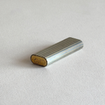 Base of a Les Must de Cartier stainless steel table lighter with gold-plated stripes and engraving