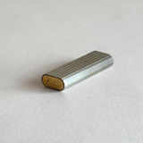 Base of a Les Must de Cartier stainless steel table lighter with gold-plated stripes and engraving