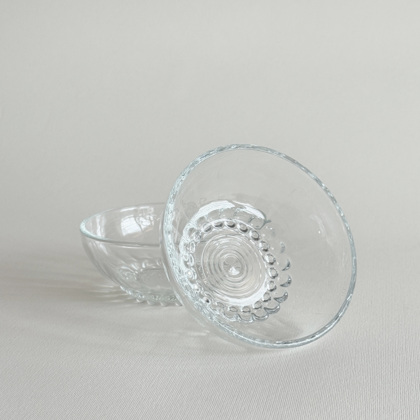 Set of 2 clear pressed glass bowls with bubble feet and round rims from mid-20th century Reims, France