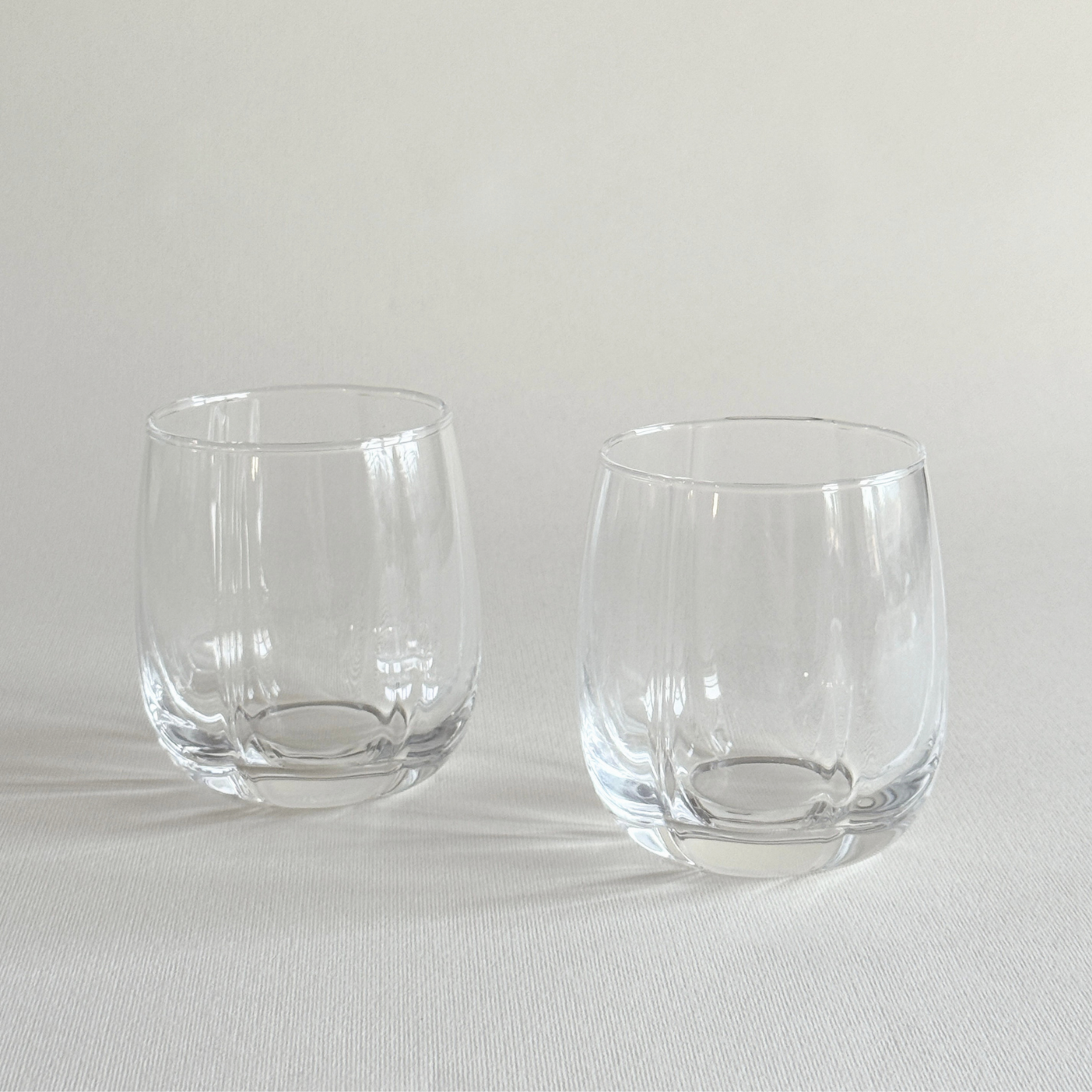 Pair of ribbed crystal tumblers with vertical fluting catching the light