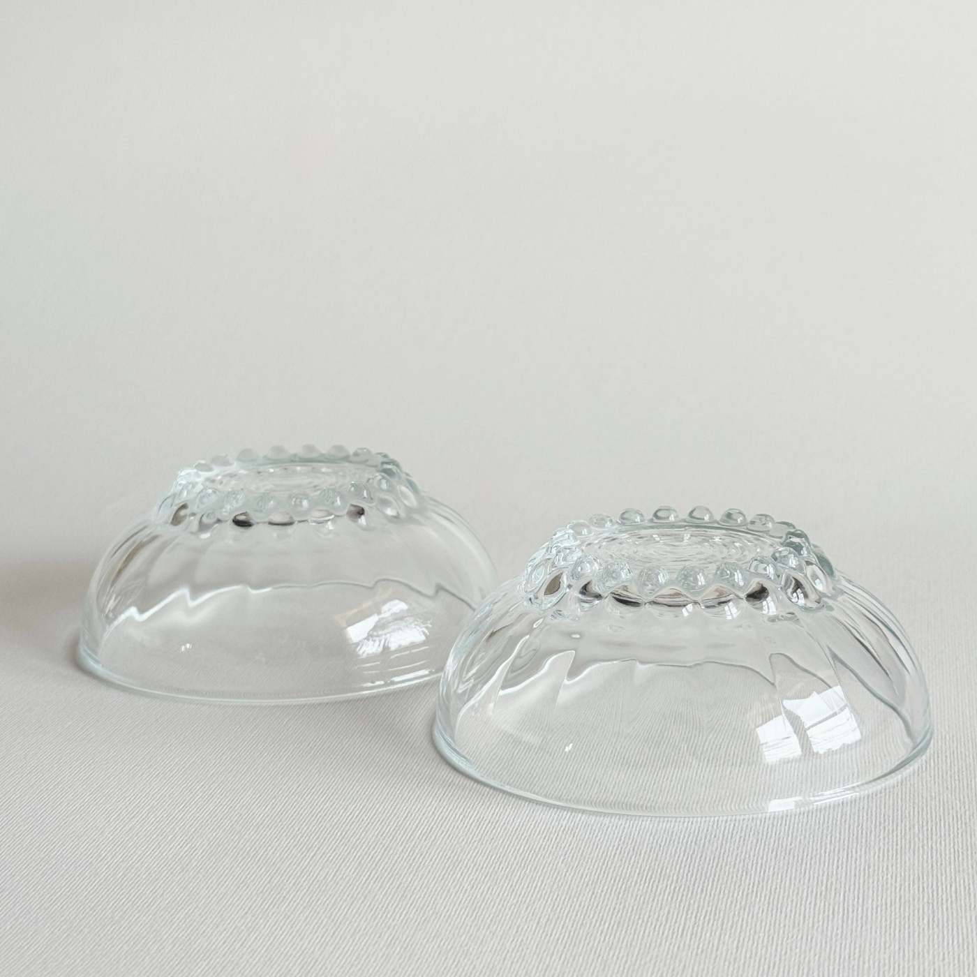 Set of 2 clear pressed glass bowls with bubble feet and round rims, mid-20th century French design from Reims, ideal for desserts or condiments.