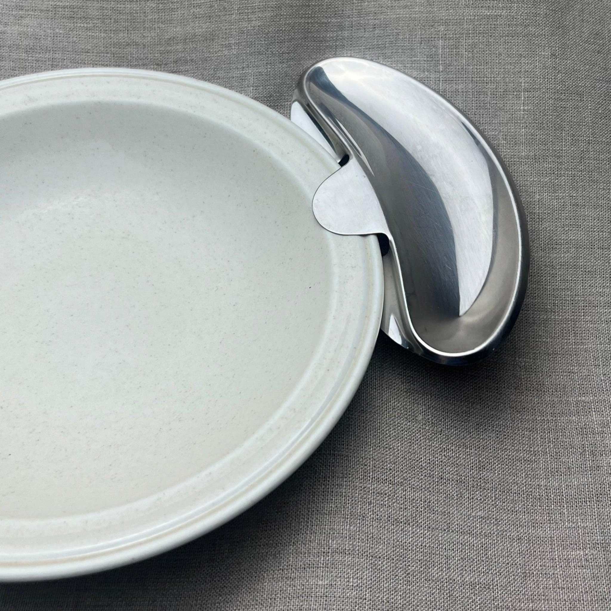 AMC Metal side plate stainless steel curved condiment tray attached to white ceramic plate with notch for secure fit