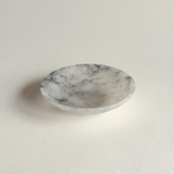 Small alabaster tray with natural veining styled on neutral surface