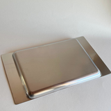 Polished stainless steel serving tray with Alessi logo sticker
