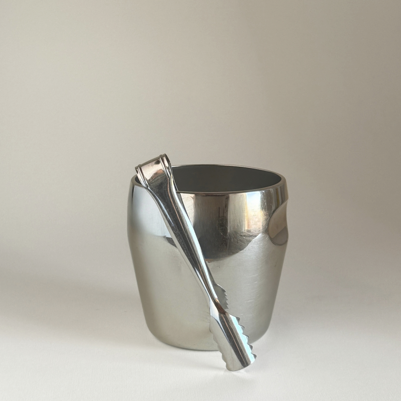 Alessi 871 Ice Bucket in mirror-polished stainless steel with matching ice tongs, smooth rounded cylindrical design