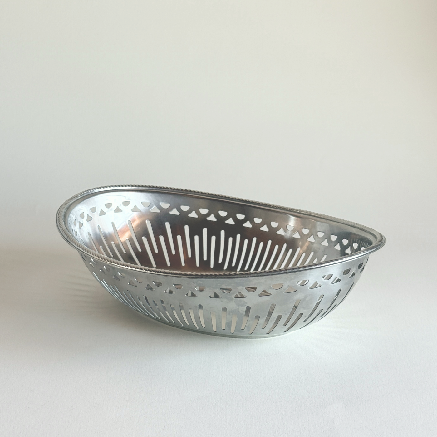 Brushed stainless steel Alessi bread basket in silver, Mercurio design with fine linear texture