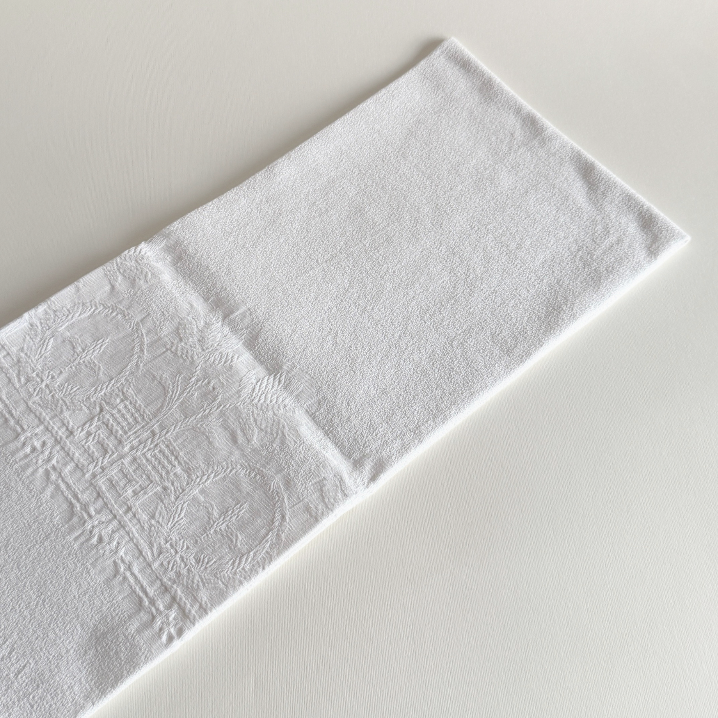 Detail of the embroidered fleur-de-lys motif on the jacquard cotton