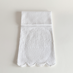 Antique white cotton hand towel with floral and fleur-de-lys jacquard, laid flat