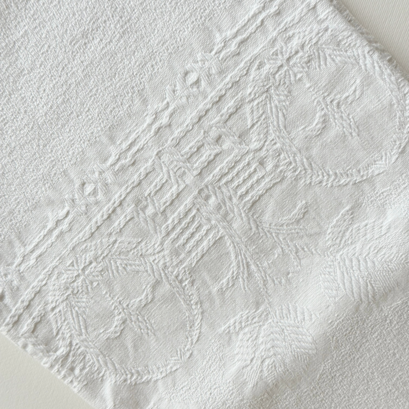 Scalloped-edge cotton hand towel draped over a rail