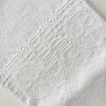 Scalloped-edge cotton hand towel draped over a rail
