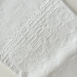 Scalloped-edge cotton hand towel draped over a rail
