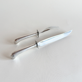 Silver-plated carving knife and fork laid together, vintage serving cutlery