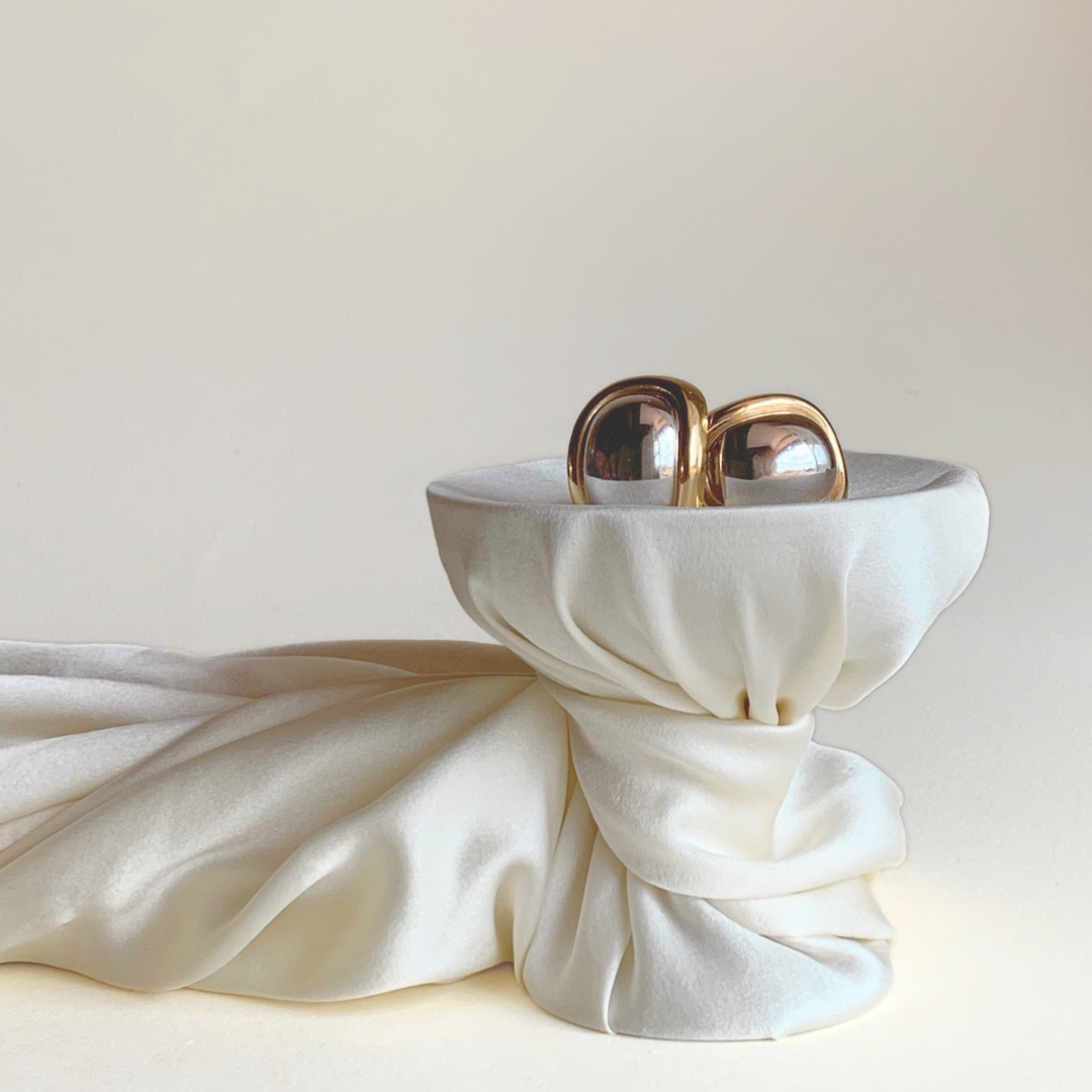 dior earrings on cup with silk