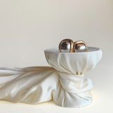 dior earrings on cup with silk