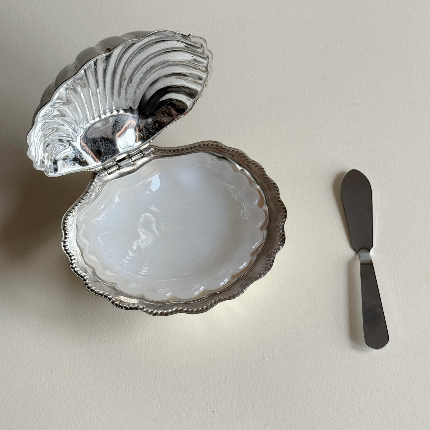Compact silver shell serving dish for caviar and butter presentation