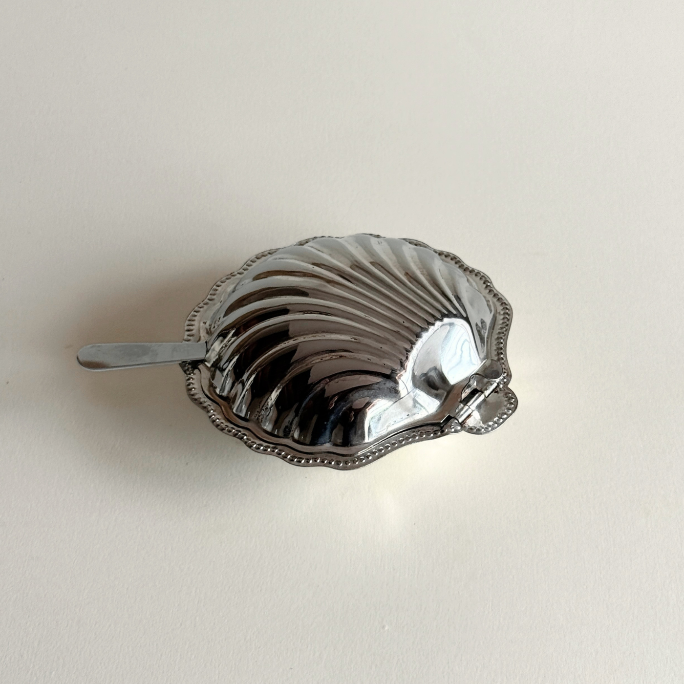 Compact silver shell serving dish for caviar and butter presentation
