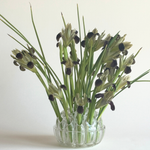 Bohemian Glass Flower Frog in clear pressed glass, with a rounded bowl shape and stems held upright in its holes.