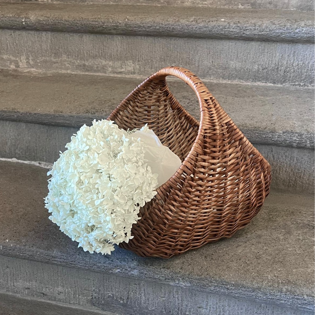 Wicker basket with white flowers on a wooden staircase