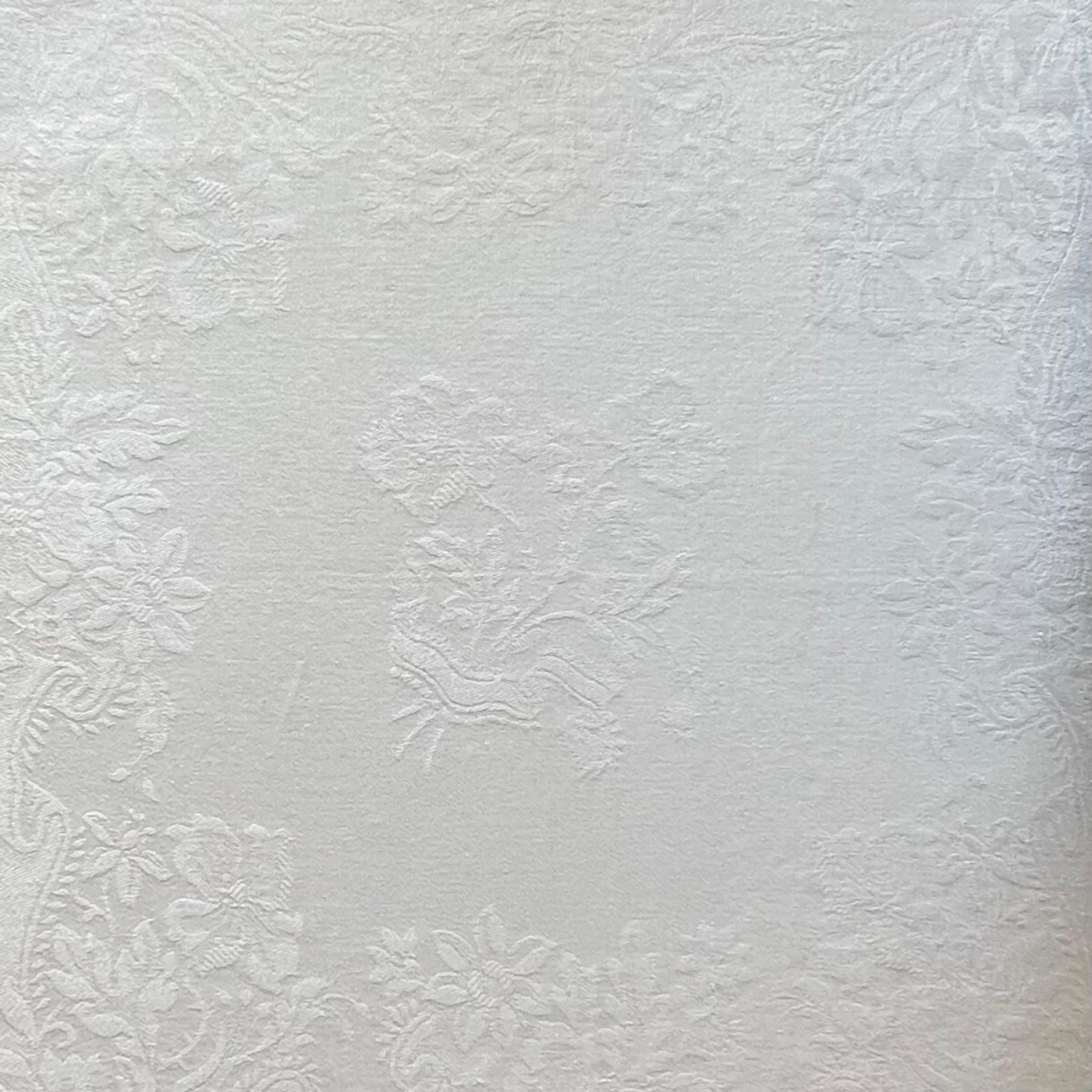 White jacquard cotton napkin folded on a beige background