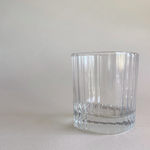 Whisky tumbler with striped glass design on table