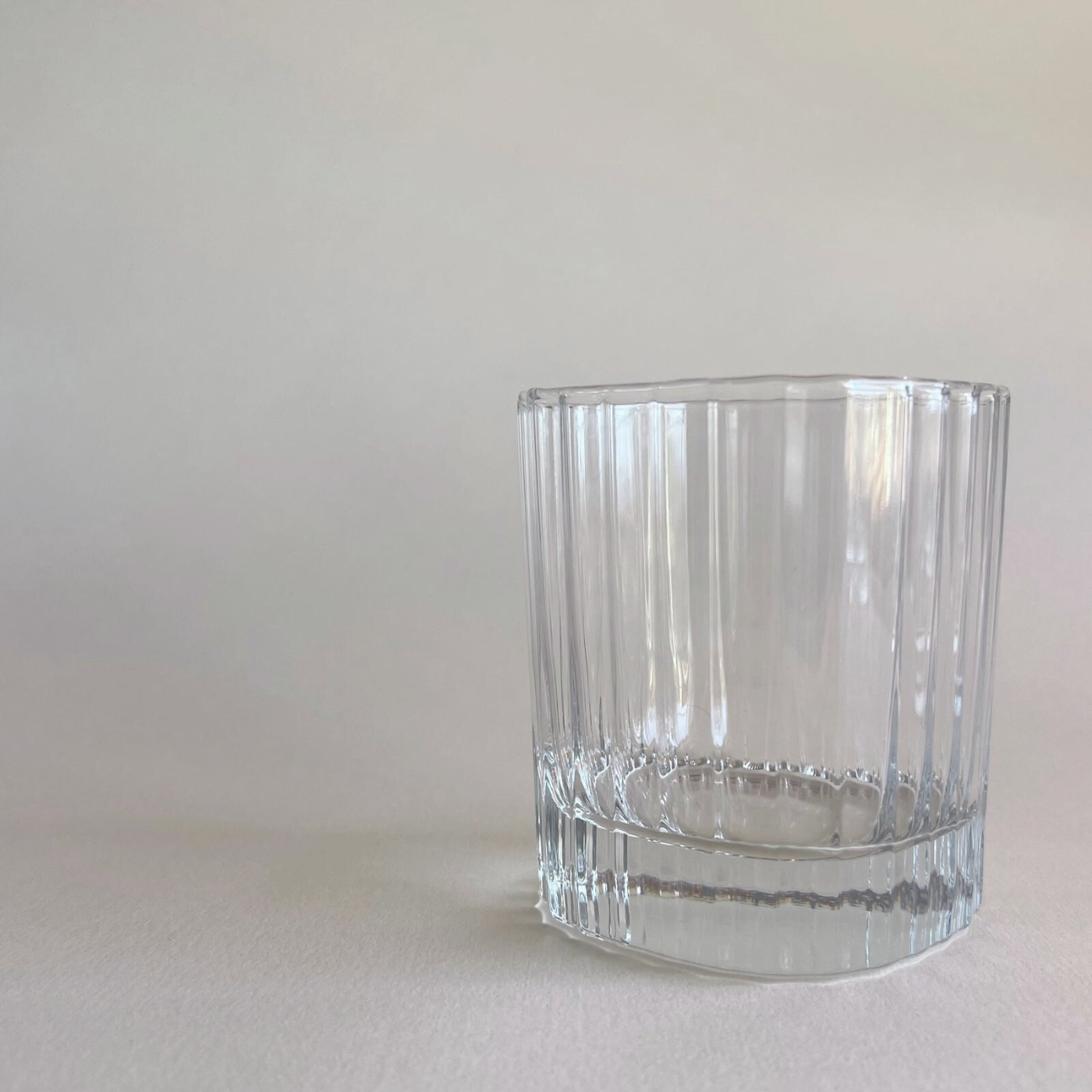Whisky tumbler with striped glass design on table