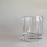 Whisky tumbler with striped glass design on table