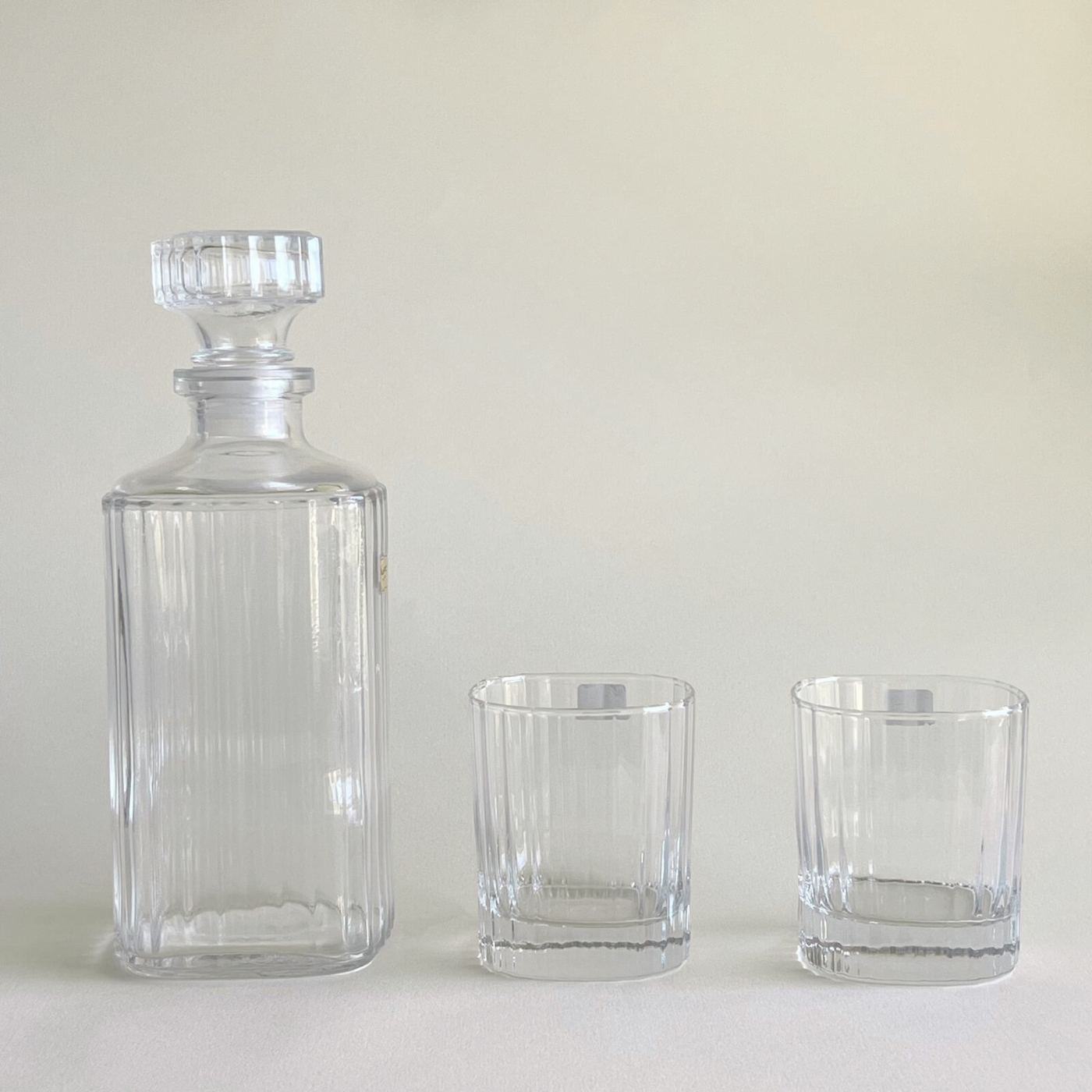 Striped glass tumbler next to elegant decanter
