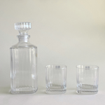 Striped glass tumbler next to elegant decanter
