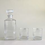 Striped glass tumbler next to elegant decanter
