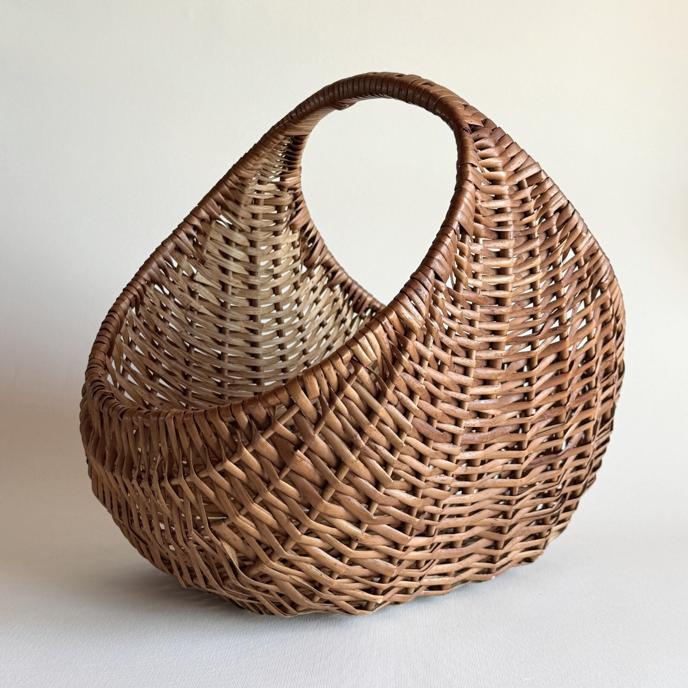 1970s Italian rattan crescent moon basket with dark, even hand-weave and deep body
