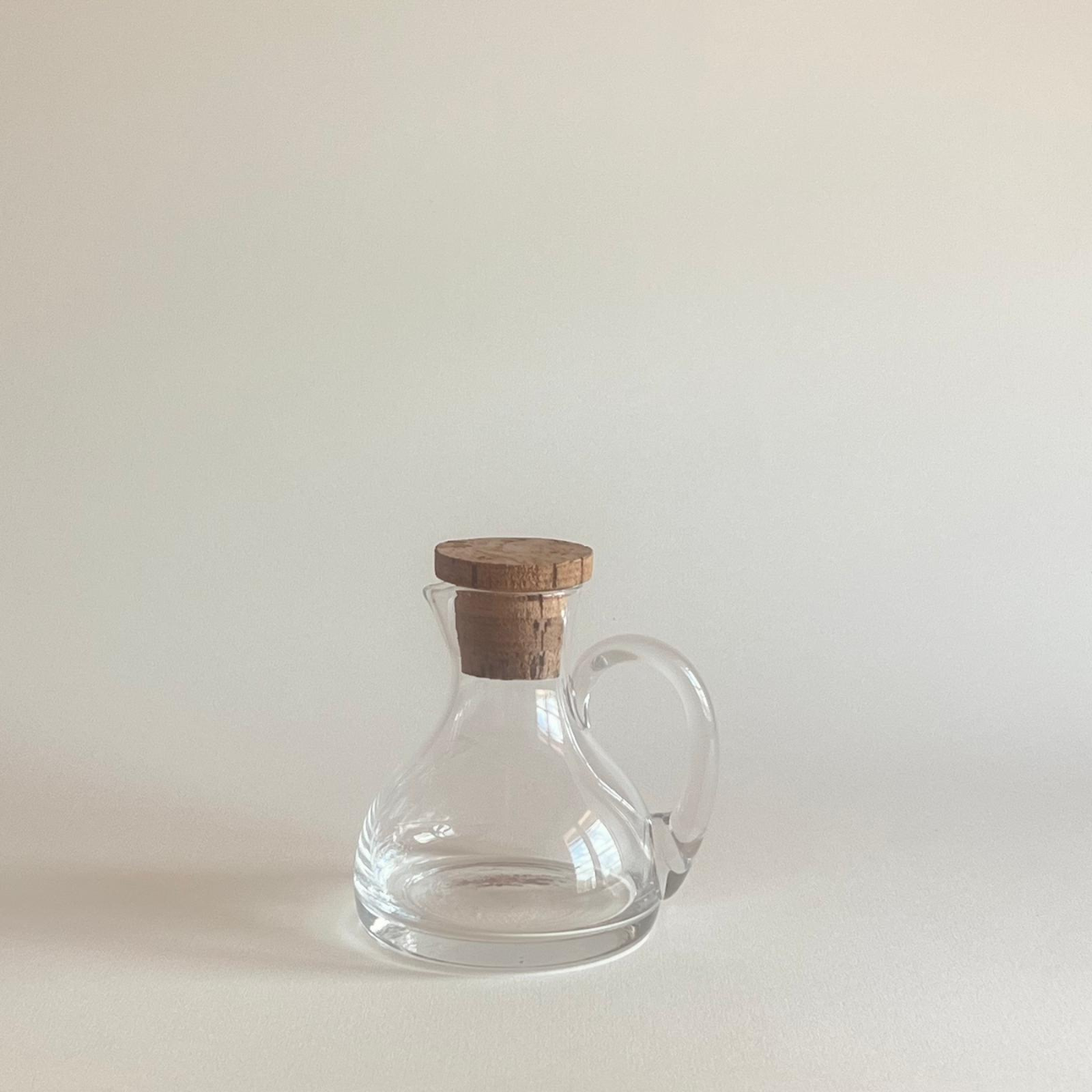 Crystal-clear oil dispenser glass bottle with natural cork lid for elegant pouring and freshness preservation