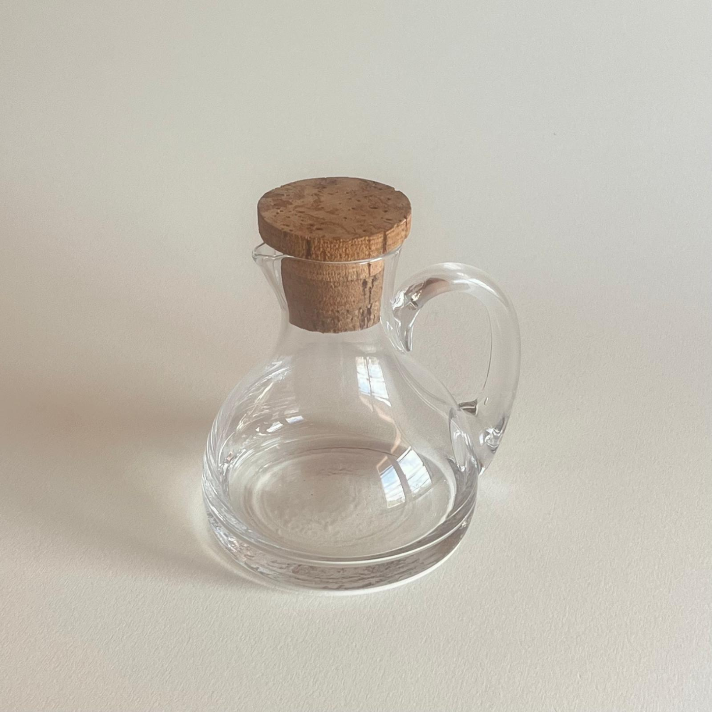 Glass oil dispenser bottle with cork lid for elegant dining and seasoning