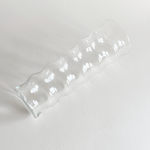 Ribbed ripple glass vase styled with a single stem on a console