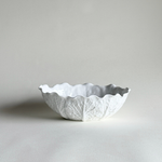 White ceramic savoy cabbage bowl with textured surface on a light background