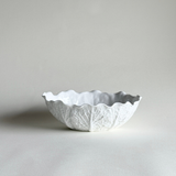 White ceramic savoy cabbage bowl with textured surface on a light background