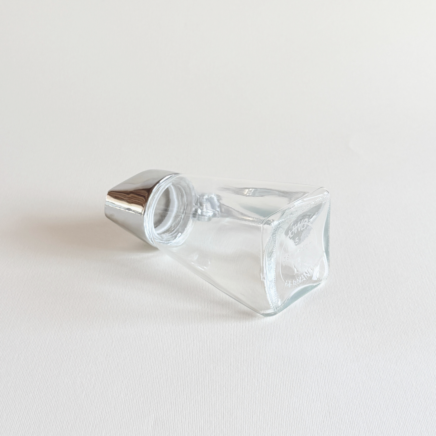 Glass sugar dispenser tipped to show the metered pour spout